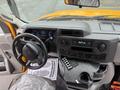 Interior view of a 2021 Ford Econoline showing the dashboard steering wheel and controls including a radio and climate controls