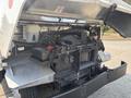 A 2018 Ford Econoline with the hood lifted exposing the engine compartment and various engine components such as the battery and coolant reservoir