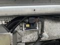 A close-up view of a 2012 Workhorse W62 engine component featuring wiring and a black device with a yellow label mounted on a metal surface