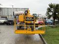 A 2020 Haulotte HA61 LE PRO boom lift with a yellow frame and a platform for elevated work is parked on a pathway