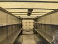 Interior of a 2012 Ford Econoline van with metal shelves on both sides and a closed back door