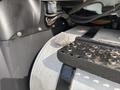 Close-up of a 2013 International WorkStar's fuel tank cap resting on a metal fuel tank with visible bolt and hose connections