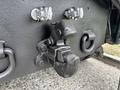A close-up of a coupler on a 2013 Freightliner 114SD showing metallic components and bolts with a dark finish