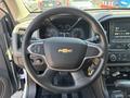 The interior of a 2017 Chevrolet Colorado showing the steering wheel with a Chevy logo and dashboard controls