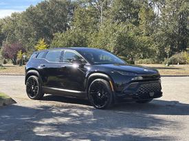 A black 2023 Fisker Ocean SUV is parked, featuring a sleek design with bold lines and large black wheels