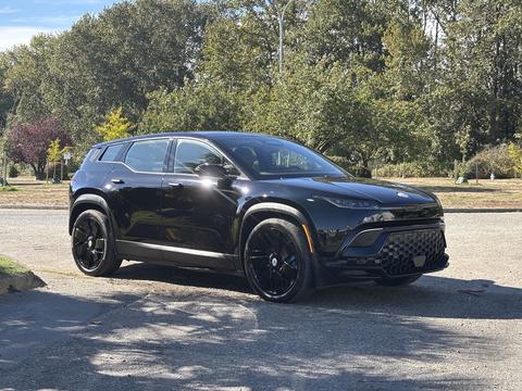 A black 2023 Fisker Ocean SUV is parked, featuring a sleek design with bold lines and large black wheels