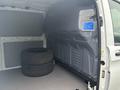 Interior of a 2021 Mercedes-Benz Metris van featuring two stacked tires resting on a clean floor with a gray panel on the side