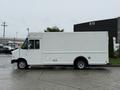A white 2012 Ford Econoline cargo van is parked with its side view visible showcasing a boxy design and large cargo area