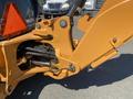 Close-up view of the hydraulic arm and mechanism of a 2016 Case 580 Super N backhoe loader in bright orange color