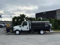 A white 2012 International TerraStar truck with a snowplow attachment and a large metal bed for transporting materials