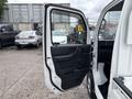 A 2008 Suzuki Carry with its driver's side door open showing the interior door panel and handle