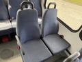Two blue upholstered seats with armrests arranged closely together inside a Chevrolet Express van