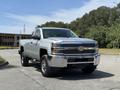 A 2016 Chevrolet Silverado 2500HD with a shiny chrome front grille and a sturdy build parked on a paved area