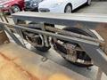 A close-up of the axle and wheel assembly of a 2013 JLG Industries 1014 featuring dual tires and metal framework