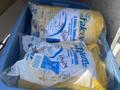 A 2013 Larson 238 boat displayed in a blue container with yellow tarps rolled and wrapped in plastic bags