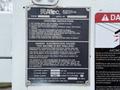 A 2005 Freightliner M2 106 with an Altec model label displaying operating instructions and safety warnings concerning electrical hazards and platform capacity