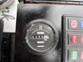 Close-up of an hours meter displaying 48451 hours on a black panel with colored buttons labeled for various functions