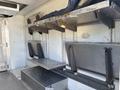 Interior view of a 2019 Freightliner MT45 showing metal shelving units and a flat workspace with multiple panels and storage areas