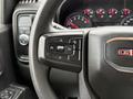 Close-up of the steering wheel controls in a 2022 GMC Sierra 1500 featuring buttons for cruise control and vehicle settings