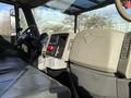 Interior dashboard of a 2010 International 4300 featuring a steering wheel various controls and a gear shift with a gray upholstery seat