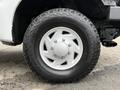 A close-up of a white wheel from a 2001 Ford F-350 featuring a five-spoke design and a rugged tire with the brand name Hankook displayed on the sidewall