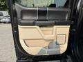 The interior door panel of a 2021 Ford F-350 SD featuring black and tan upholstery with a sleek design and panel controls