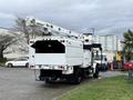 A 2015 Freightliner M2 vehicle equipped with a long crane arm mounted on the top for lifting and working at height