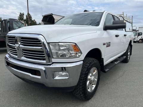 A white 2015 RAM 2500 pickup truck with chrome accents and off-road tires positioned at an angle showcasing its front and side details