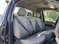 The interior of a 2022 Ford F-350 SD featuring back seats with grey fabric upholstery and seatbelts attached