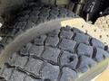 Close-up of the tread on a large truck tire showing deep grooves and rugged texture