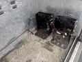 Interior of a fire truck featuring two metal seat frames with mounting holes and a disconnected cable on the floor