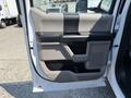 The interior door panel of a 2018 Ford F-550 featuring a gray and black design with a raised handle and a storage compartment
