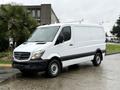 A 2017 Mercedes-Benz Sprinter van with a white exterior and black accents parked in a residential area