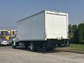A white 2012 Hino 338 box truck parked with a flatbed rear and no visible markings on the sides