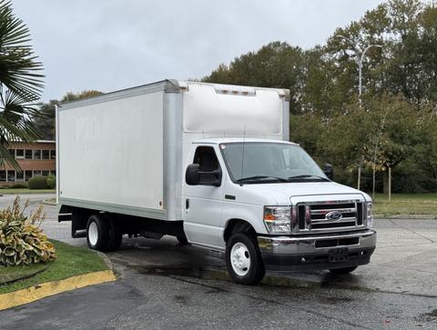 A white 2022 Ford E-450 box truck with a closed freight compartment and dark wheels parked on a driveway