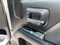 Interior door handle and control panel of a 2020 Chevrolet Silverado showing the handle and window controls