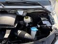 A view of the engine compartment of a 2016 Mercedes-Benz Sprinter showing various components including the air filter and the battery