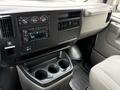 Interior dashboard of a 2004 Chevrolet Express with controls for climate and audio systems along with a cup holder section
