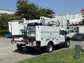 A 2008 Ford F-550 bucket truck with a mounted aerial lift and utility storage compartments on the rear