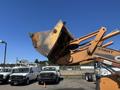 A 2011 Case 570 MXT construction loader with an elevated bucket showing signs of wear and tear