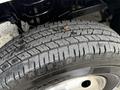 Close-up of a tire from a 2013 RAM 3500 showing tread pattern and a small object embedded in the rubber