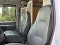 Interior view of a 2008 Ford Econoline showing two gray front seats and a partition behind them