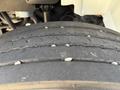 Close-up view of a tire on a 2012 International DuraStar 4300 showing tread wear and small stones embedded in the rubber surface