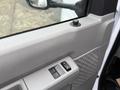 Close-up of the interior door panel of a 2019 Ford Econoline showing window controls and a textured armrest