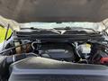 An open hood of a 2020 Ram 2500 revealing the engine compartment with various components including hoses and a battery