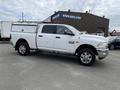 A 2015 RAM 2500 pickup truck in white with a utility bed and chrome wheels parked on a lot