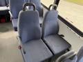 Two blue upholstered bus seats with armrests in a row positioned towards the front of the vehicle