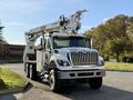 A 2011 International 7500 bucket truck featuring a raised aerial lift and additional work equipment mounted on the chassis