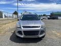 A silver 2015 Ford Escape facing forward with a sleek design and distinctive grille featuring the blue Ford logo