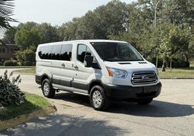 A 2017 Ford Transit van with a white exterior and black trim parked on a roadway